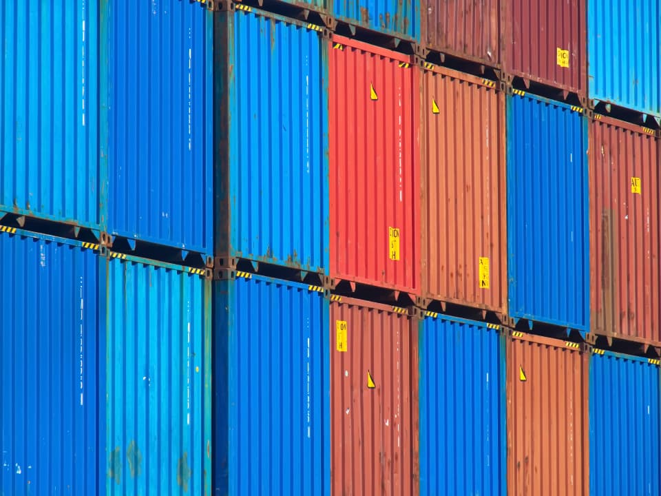 Conteneurs maritimes colorés empilés dans un terminal portuaire.