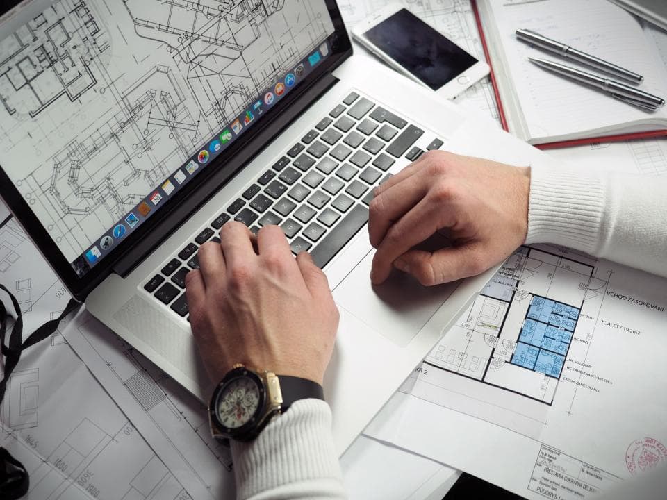 Ordinateur portable et documents de travail sur un bureau.