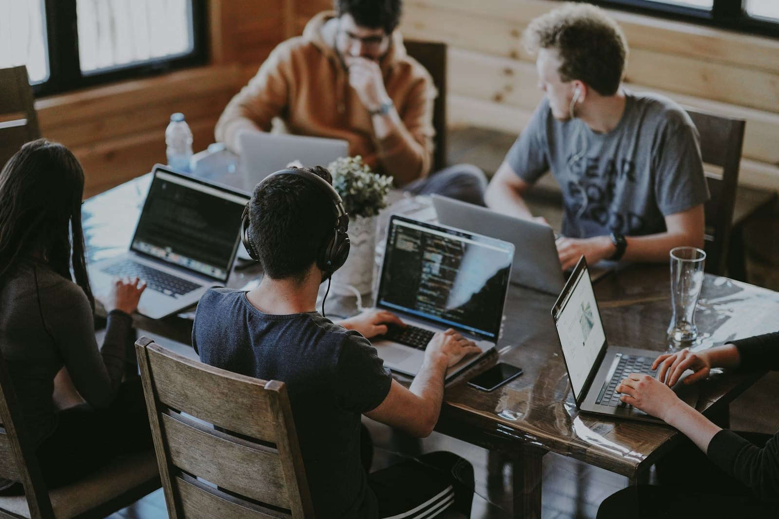 Petite équipe réunie autour d'une table de travail avec ordinateurs portables, collaboration en cabinet.