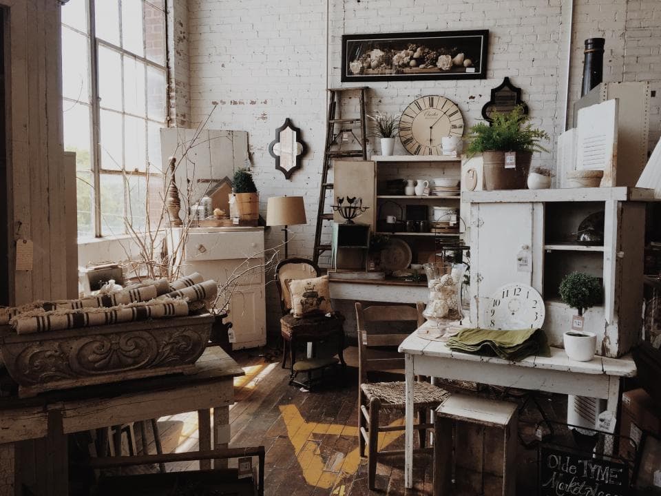 Boutique remplie de marchandises et d'objets rangés sur des étagères en bois.