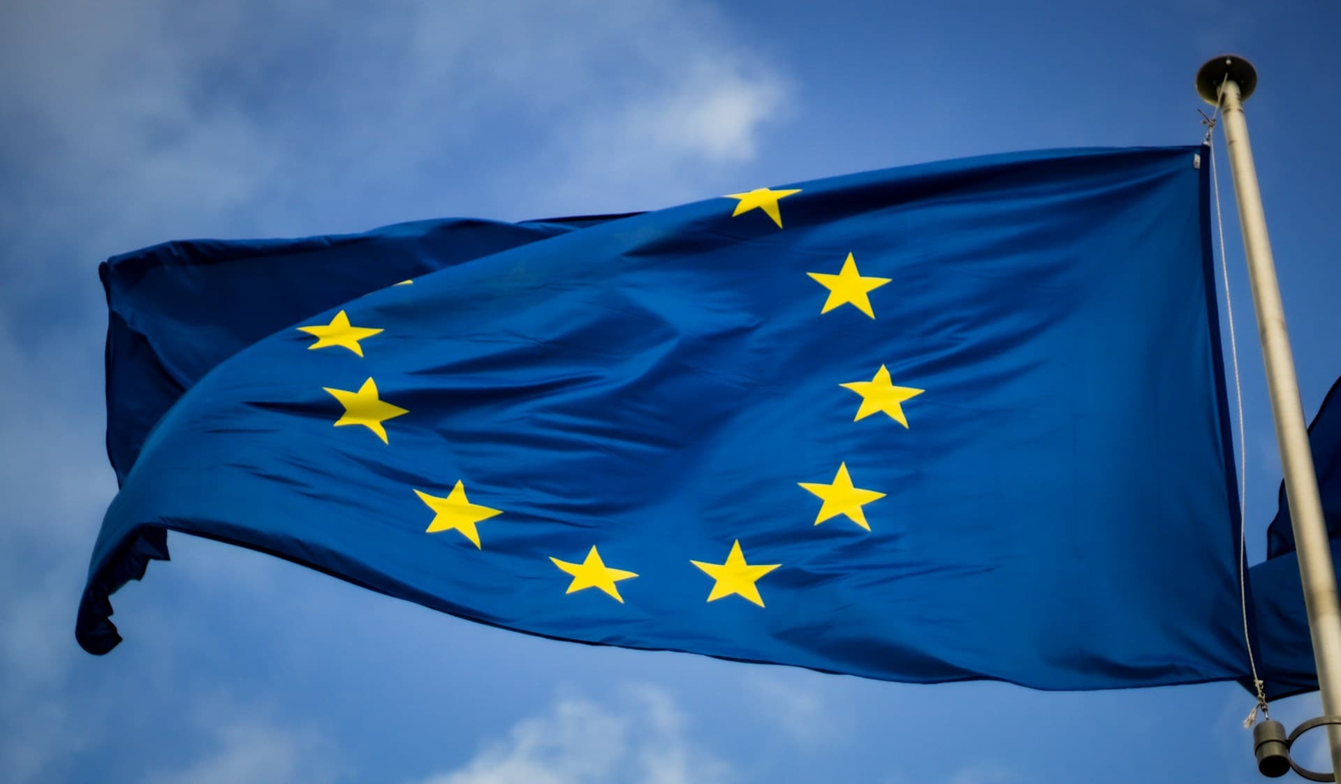 Drapeau de l'Union européenne devant le Parlement européen, symbole de souveraineté numérique.