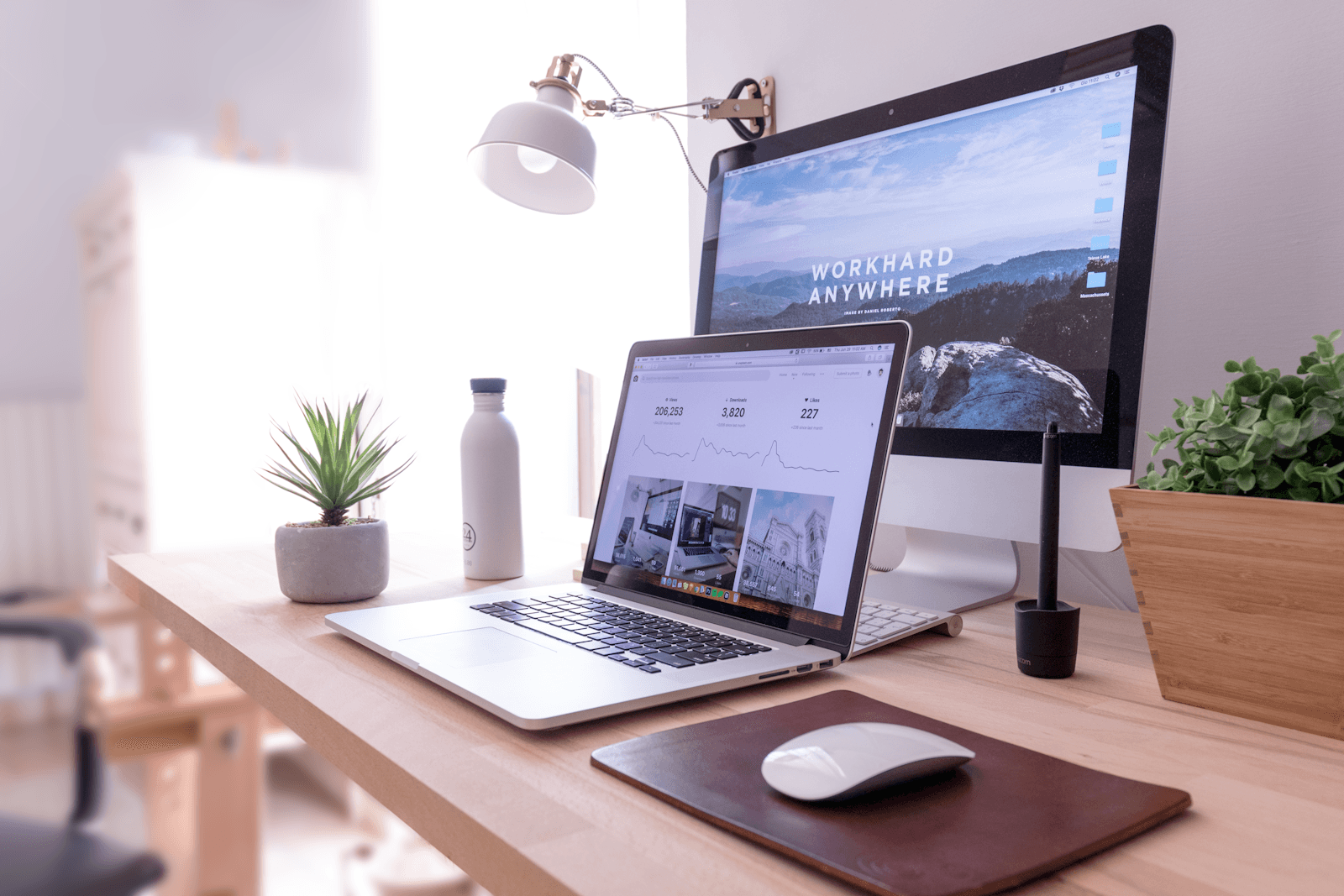 Bureau épuré et organisé avec ordinateur portable et écran, espace de travail maîtrisé.