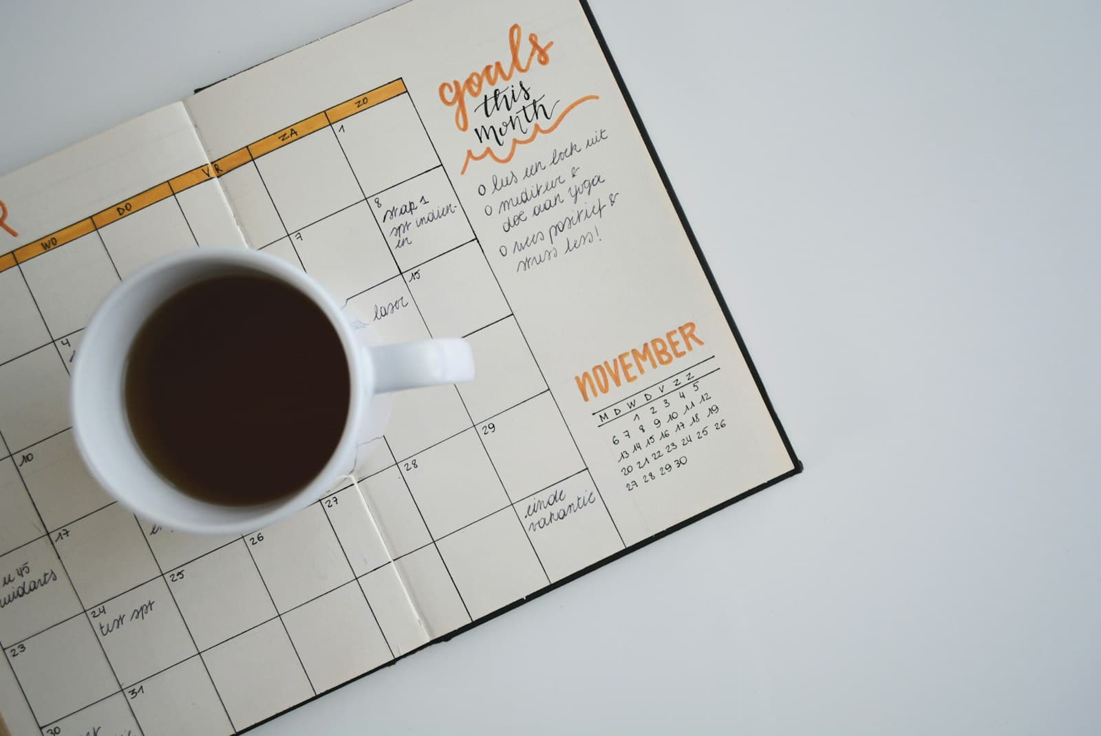 Agenda ouvert et ordinateur portable sur un bureau, organisation des rendez-vous et du suivi client.