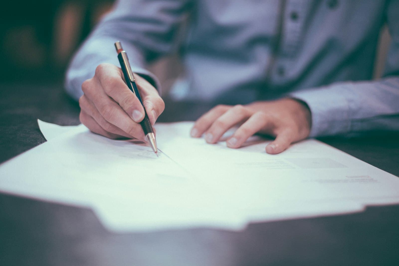 Personne signant un document d'une main, validation rapide d'un accord.